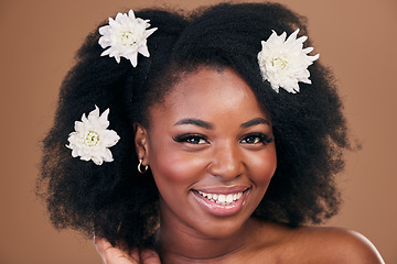 Image showing Afro, hair care or portrait of black woman with flowers, beauty or smile on a brown studio background. Hairstyle, floral or happy African model with shine and volume with aesthetic, wellness or glow