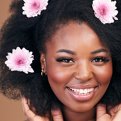 Image showing Face, flowers and black woman in afro hair care, happy and beauty in studio isolated on a brown background. Portrait, floral hairstyle cosmetics and natural African model in organic salon treatment