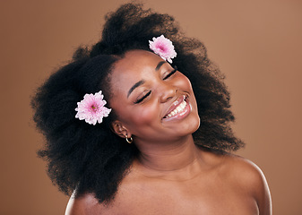 Image showing Hair care, flowers and black woman, happy and beauty in studio isolated on a brown background. Smile, floral afro cosmetics or natural African model in organic salon treatment, wellness and hairstyle