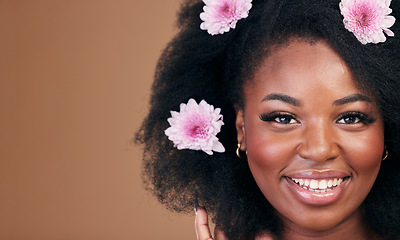 Image showing Flowers, face and black woman in afro hair care, smile and beauty in studio isolated on a brown background mockup space. Portrait, floral hairstyle cosmetic and natural African model in organic salon