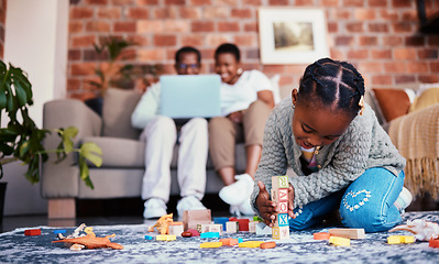 Image showing Playing, house and a child with building blocks and parents on the sofa with a laptop and relax. Happy, black family and a girl kid with toys on the lounge floor for education, learning and a game