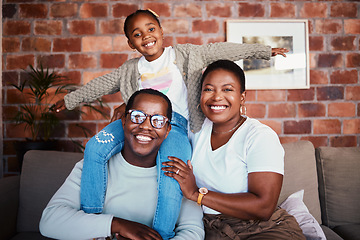 Image showing Portrait of black family in home, parents and kid on sofa with piggy back, bonding and relax in lounge. Mom, dad and girl child on couch in apartment with playful man, woman and daughter together.