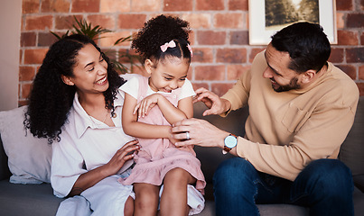 Image showing Family, happy and laughing while playing on a home sofa with tickle fun, bonding and time together. A happy man, woman and girl kid in a lounge with love, care and happiness in house in Puerto Rico