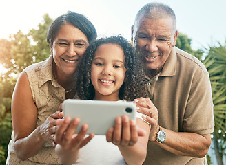 Image showing Girl child, grandparents and selfie in garden, backyard or park with smile, hug and care for post on social media. Senior man, woman and female kid with photography, profile picture or memory on blog