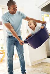 Image showing Child, father and playing in laundry basket at home for family fun and housework or cleaning. A man laughing and swinging a funny toddler kid while together for bonding, game and development at house