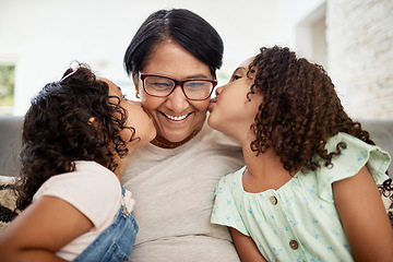 Image showing Kids kissing their grandmother on the cheek with care, love and happiness while relaxing in the living room. Smile, happy and senior woman hugging girl children for bonding together at family home.