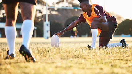 Image showing Rugby ball, kick and sport game with holding support, exercise and competition with athlete training. Field, black man and target practice on grass with fitness and team workout outdoor for teamwork