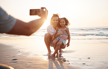 Image showing Phone photography, father and daughter at beach, sunset sky and happy for memory, holiday and bonding. Smartphone, profile picture and man with girl child, hug and care for post, social media and sea