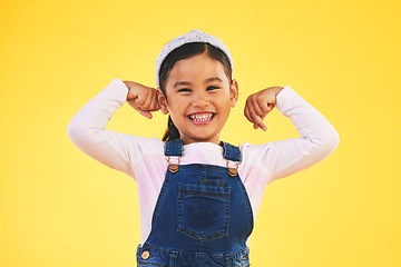 Image showing Smile, portrait and girl child with arm flex in studio for confidence, strong and power on yellow background. Happy, face and excited kid with bicep strength, pose or empower, positive or growth sign