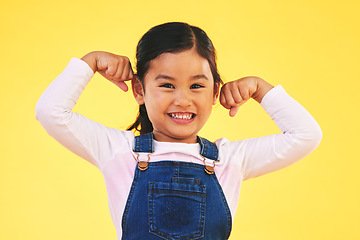 Image showing Happy, portrait and girl child with arm flex in studio for confidence, strong and power on yellow background. Face, smile excited kid with bicep strength, pose and empowered, positive and growth sign