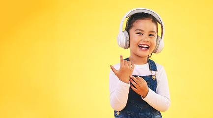 Image showing Portrait, happy and girl child with music headphones in studio for streaming subscription on yellow background. Face, smile and kid with headset for podcast, radio or audio, track and album playlist