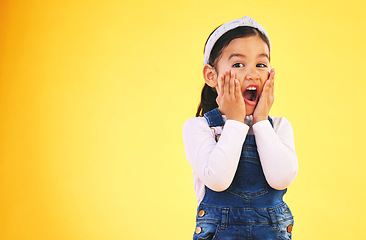 Image showing Fashion, surprise and hands on face of girl child in studio wow, omg or wtf for promo, deal or giveaway on yellow background. Portrait, emoji and kid with open mouth for news, info or clothes sale