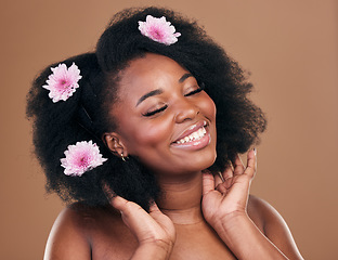 Image showing Afro, hair or happy black woman with flowers, beauty care or smile on a brown studio background. Hairstyle, floral or natural African female model with shine or growth with volume, wellness or glow