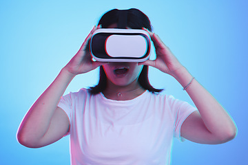 Image showing Woman, VR technology and surprise in studio for user experience, digital world and future multimedia game on blue background. Virtual reality glasses, metaverse and wow for innovation of UX gaming