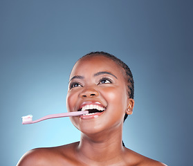 Image showing Black woman, face or toothbrush for cleaning teeth on isolated blue background, studio or mockup space. Smile, model or dental toothpaste for gum wellness, breath or mouth hygiene in grooming routine