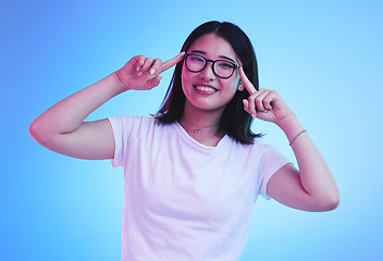 Image showing Portrait, thinking and Asian woman with glasses, ideas and opportunity on a blue studio background. Japanese person, face and model with eyewear, solution and decision with problem solving and choice