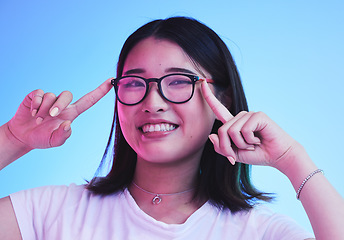 Image showing Portrait, smile and woman with glasses on blue background in studio for optometry style. Happy asian model, gen z girl and face with spectacles for fashion, eye care and lens choice of cool frames