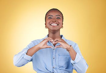 Image showing Portrait, heart hands and black woman, smile and studio isolated on yellow background. Face, love sign and happy African person in kindness, care and empathy, support and trust, romance or solidarity