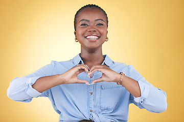 Image showing Happy black woman, portrait and heart hands for support, love or care against a yellow studio background. Face of African female person smile with loving emoji, shape or symbol icon on valentines day