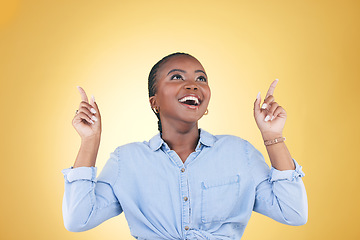 Image showing Black woman, excited and surprise, pointing up and advertising with presentation news isolated on yellow background. Announcement, opportunity and offer with wow, communication and ads in studio