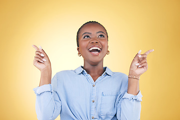 Image showing Pointing up, choice or excited black woman in studio for mockup space, sale news or deal offer. Yellow background, advertising or happy person thinking of promotion ideas, announcement or retail deal