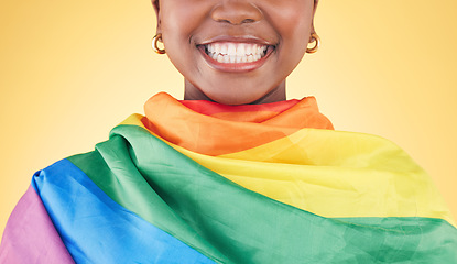 Image showing Woman, mouth closeup and rainbow flag in studio for smile, teeth or happy for inclusion by yellow background. Lesbian girl, cloth or fabric for lgbtq equality, gay pride or excited for sign or vote