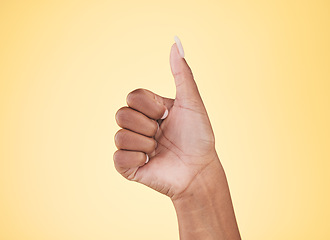 Image showing Woman, hands and thumbs up in winning, success or approval against a studio background. Closeup of female person with like emoji, yes sign or okay in thank you, agreement or finger gesture on mockup