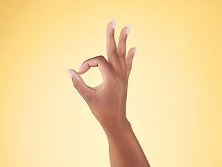 Image showing Great, ok and hand sign in studio with decision, agreement and success of good news. Yellow background, yes vote and accept approval of a person showing agree, opinion and emoji icon and signal