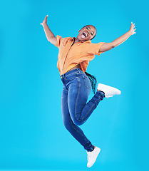 Image showing Jump, black woman and excited portrait with motivation in studio from celebration smile. Happy, energy and African female person with promotion and blue background with leap from deal announcement