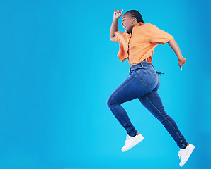 Image showing Jump, black woman and excited with motivation in studio from celebration and smile. Happy, energy and African female person with mockup space and blue background with leap from deal and announcement