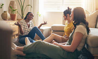 Image showing Happy, gossip and friends on a floor relax, talking and bond with advice in house together. Conversation, drama and women with diversity in a living room speaking, chilling and enjoy weekend freedom