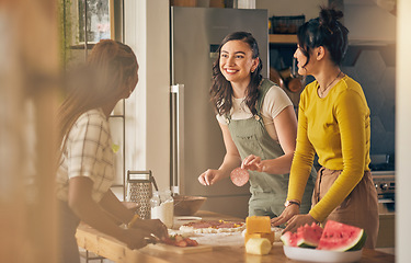 Image showing Happy, friends and women cooking pizza in kitchen, bonding and having fun together in home. Smile, girls and baking food, margherita and salami bread at lunch, cheese on meat and watermelon at brunch