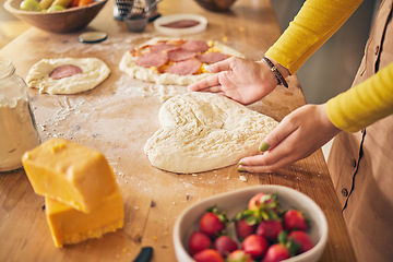 Image showing Pizza, heart with dough and hands on wooden table, person cooking with flour and cheese, fruit and food at home. Nutrition, meal and strawberry in kitchen, baking with ingredients and love sign