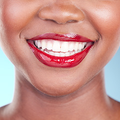 Image showing Woman, smile and red lipstick with teeth and beauty, dental and makeup closeup isolated on blue background. Model with bold cosmetic product on lips, dental and mouth with skin and shine in studio