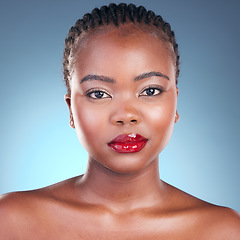 Image showing Portrait, beauty and black woman with makeup, cosmetics and dermatology on a blue studio background. Face, African person and model with red lips, gloss and glow with aesthetic, shine and skincare