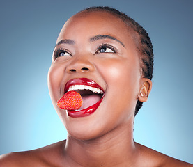 Image showing Skincare, strawberry and black woman with beauty, health and wellness on a blue studio background. Person, fruit and model with cosmetics, diet and nutrition with grooming, aesthetic and dermatology