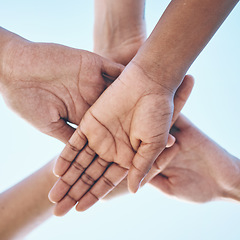 Image showing Blue sky, hands stack and together for team building motivation, group cooperation or community goals support. Closeup below view, synergy commitment and people collaboration, teamwork and solidarity