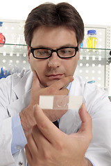 Image showing Scientist studies a microscope slide