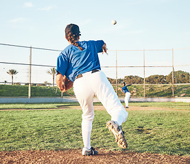 Image showing Baseball, pitching and a sports person outdoor on a pitch for performance or competition. Behind professional athlete or softball player with fitness, ball and throw for game, training or exercise