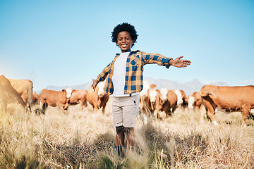 Image showing Farm, cows and portrait of child with open arms for ecology, adventure or agriculture in field. Countryside, sustainable farming and happy African kid smile for freedom, relax or learning with cattle