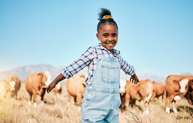 Image showing Farm, cows and portrait of girl with open arms for ecology, adventure and agriculture in field. Countrysid , sustainable farming and happy African kid for freedom, relax and learning with cattle