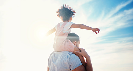 Image showing Kid on father shoulders, blue sky and family with travel, back view and freedom with fun together outdoor. People in nature, sunshine and adventure, man and girl bond with tropical holiday and beach