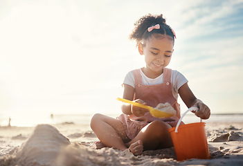 Image showing Sun flare, beach and happy girl with sand, toys and vacation with happiness, playing and cheerful. Kid, shore and female child with fun, getaway trip and adventure with seaside holiday or development