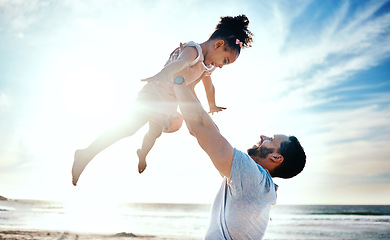 Image showing Father lifting child, air and beach with family, travel and freedom outdoor, happiness and ocean with girl and man. Happy people, sunshine and tropical vacation, kid flying with dad and adventure