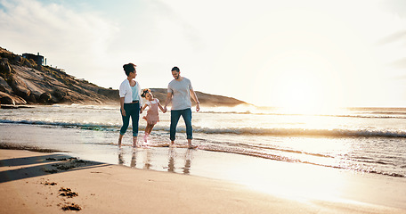 Image showing Walking, bonding and family on the beach for vacation, adventure or holiday together at sunset. Travel, having fun and girl child with her mother and father on the sand by the ocean on weekend trip.