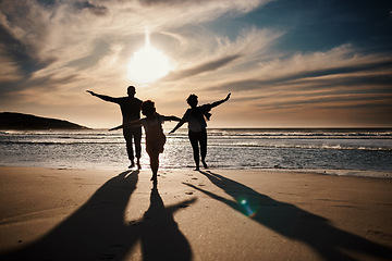Image showing Family, running and silhouette on beach with sunset, freedom and fun together, games and bonding on vacation. Travel, adventure and playful, parents and child with happy people in nature and energy