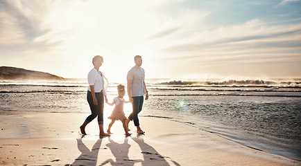 Image showing Beach, sunset and family holding hands, walking and bond, relax and happy on vacation in nature together. Travel, love and girl chid with parents at ocean with freedom, adventure or journey in Bali