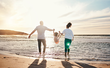 Image showing Dad, mom and swing girl on beach, holiday and vacation in Florida for bonding, adventure and family together in waves. Mother, father and child at sunset in ocean, sea or playing in water for fun
