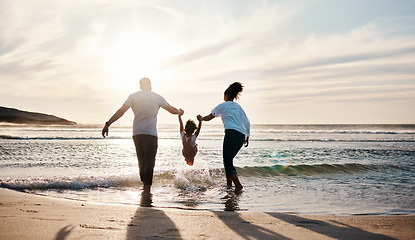 Image showing Mom, dad and swing girl on beach, holiday and vacation in Florida for bonding, adventure and family together in waves. Mother, father and child at sunset in ocean, sea or playing in water for fun