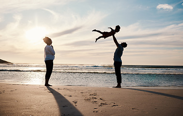 Image showing Family, beach and child in air with parents, sunshine with happiness and together with bonding on vacation. Travel, adventure and mother, father and kid flying, happy people in nature with silhouette
